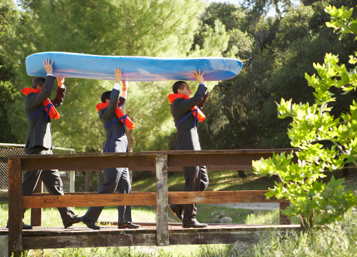 3 men carrying a kayak