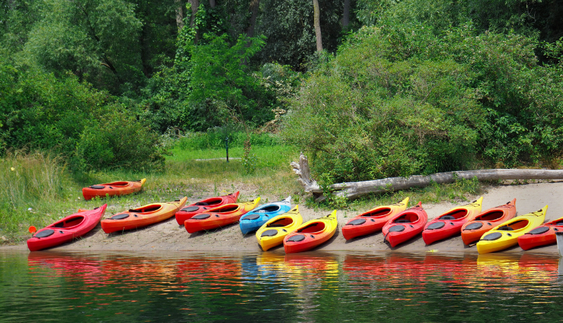 a bunch of kayaks readied for long camping trips