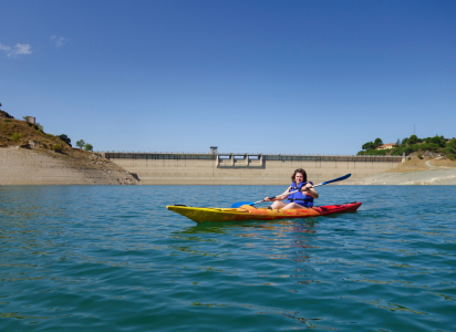 a woman safely kayaking in a dam
