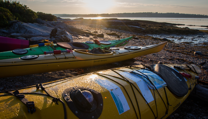 camping kayakers on the shore of a beach taking a rest